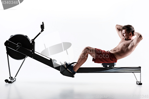 Image of Man Using A Press Machine In A Fitness Club.
