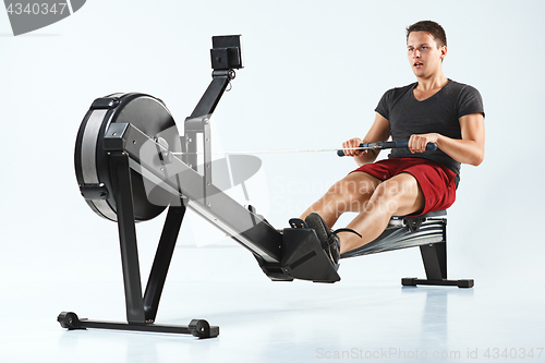 Image of Man Using A Press Machine In A Fitness Club.