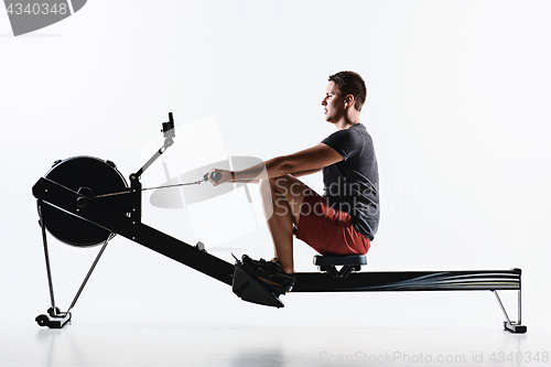 Image of Man Using A Press Machine In A Fitness Club.