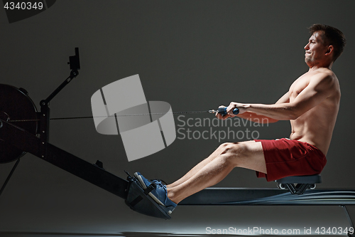 Image of Man Using A Press Machine In A Fitness Club.