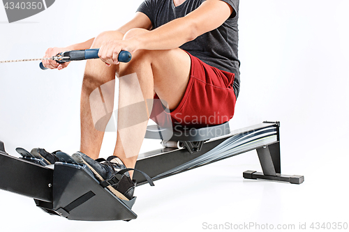 Image of Man Using A Press Machine In A Fitness Club.