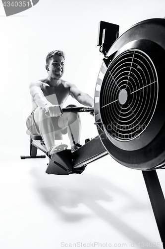 Image of Man Using A Press Machine In A Fitness Club.