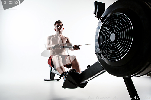 Image of Man Using A Press Machine In A Fitness Club.