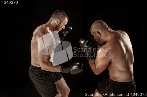 Image of Two muscular men fighting, bodybuilders punching each other, training in martial arts, boxing, jiu jitsu