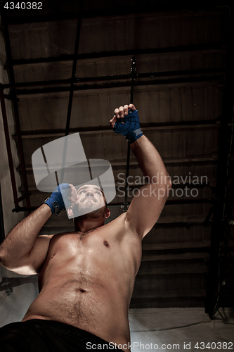 Image of The young man kickboxing on black