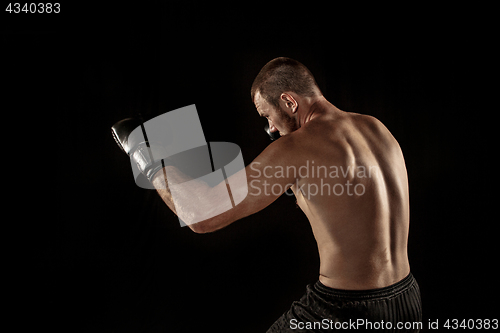 Image of The young man kickboxing on black