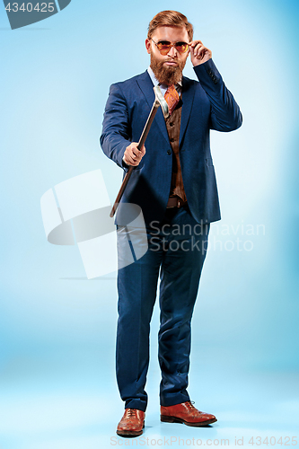 Image of The barded man in a suit holding cane.