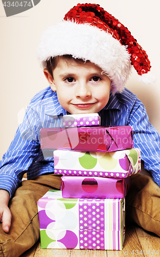 Image of little cute boy with Christmas gifts at home. close up emotional