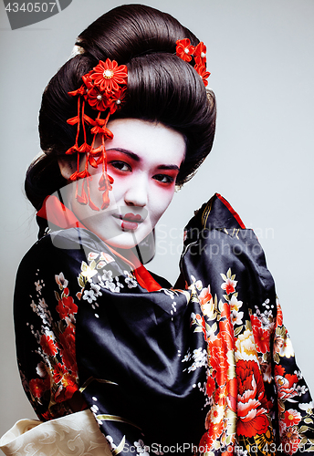 Image of young pretty geisha in kimono with sakura and red decoration design on white background