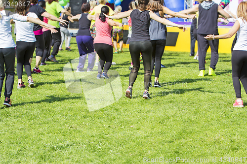 Image of Group of young girls exercising fitness with dancing in the city