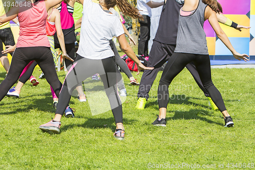 Image of Group of young girls exercising fitness with dancing in the city