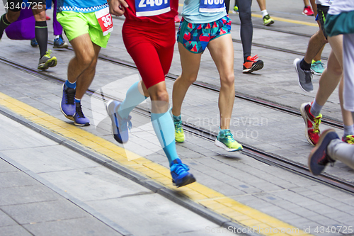 Image of Marathon runners race in city streets, blurred motion