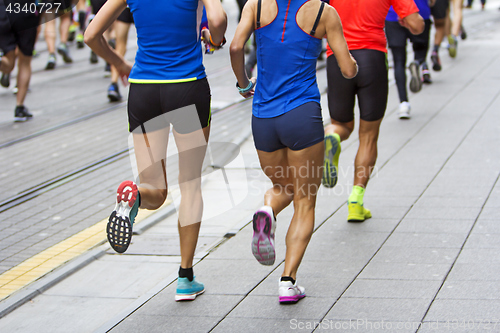 Image of Marathon runners race in city streets, blurred motion