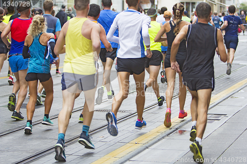 Image of Marathon runners race in city streets, blurred motion