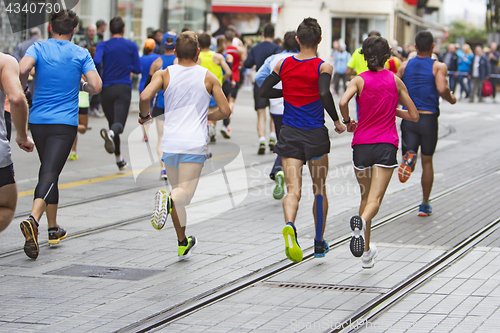 Image of Marathon runners race in city streets, blurred motion