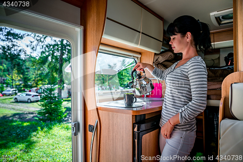 Image of Woman cooking in camper, motorhome interior RV