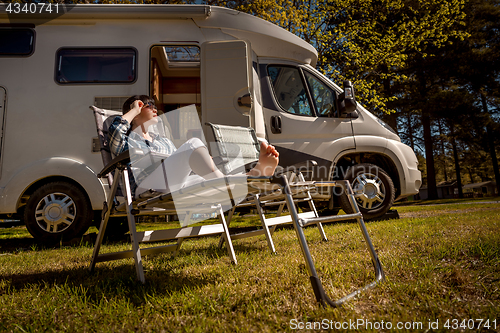 Image of Woman resting near motorhomes in nature. Family vacation travel,