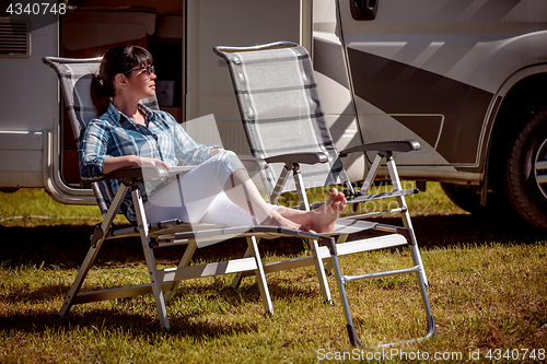 Image of Woman resting near motorhomes in nature. Family vacation travel,