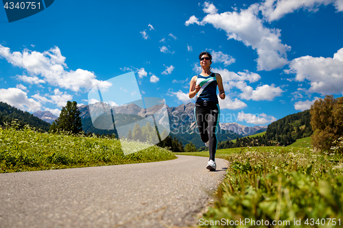 Image of Woman jogging outdoors. Italy Dolomites Alps