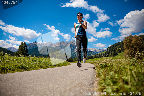 Image of Woman jogging outdoors. Italy Dolomites Alps