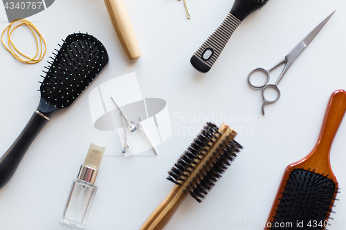 Image of scissors, hair brushes, clips and styling spray