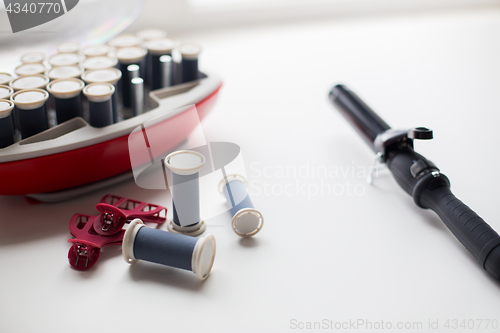 Image of hot rollers kit on table with hair clips and iron