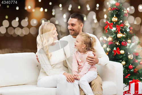 Image of happy family at home with christmas tree