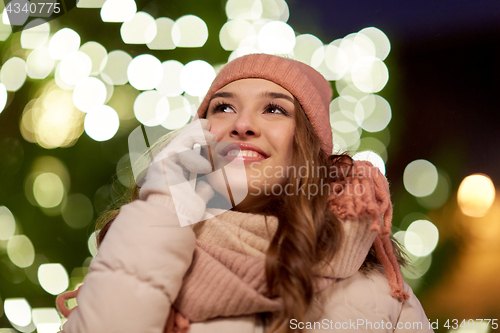 Image of happy woman calling on smartphone at christmas