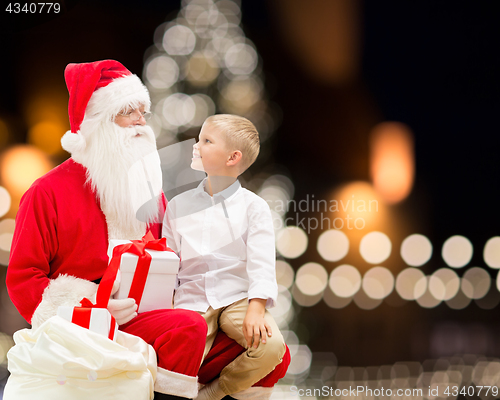 Image of santa claus and happy boy with christmas gift