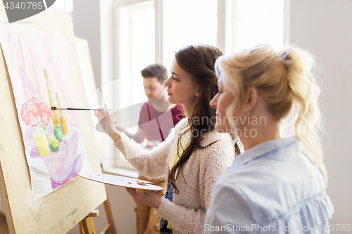 Image of artists with palette and easel at art school