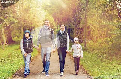 Image of happy family with backpacks hiking in woods