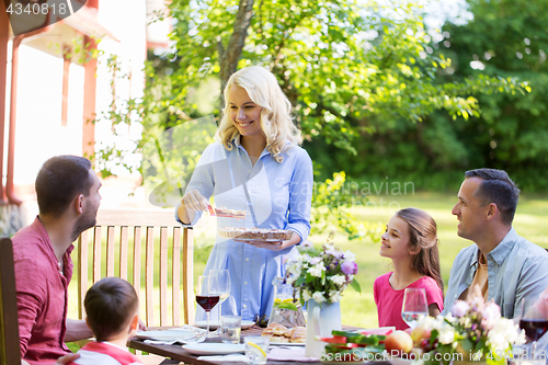 Image of happy family having dinner or summer garden party