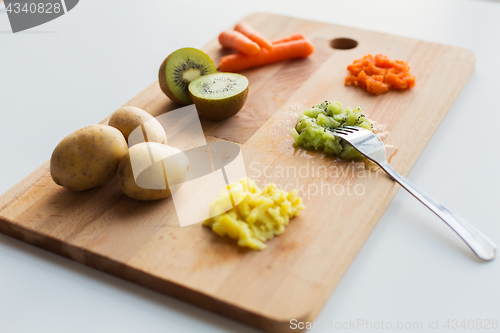 Image of mashed fruits and vegetables with forks on board