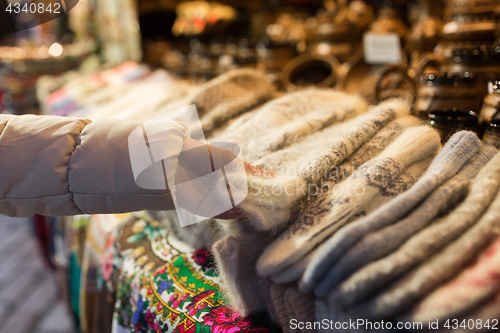 Image of woman buying woolen mittens at christmas market