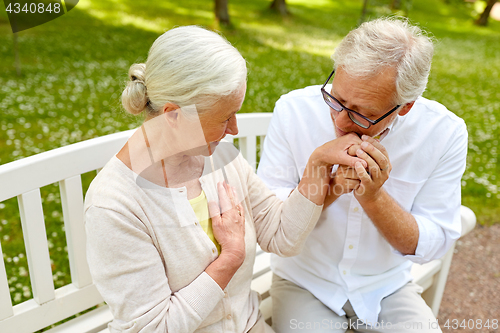 Image of happy senior couple hugging in city park