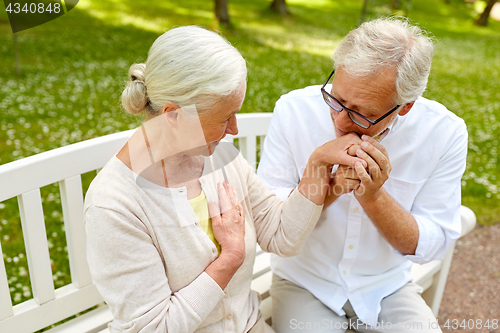 Image of happy senior couple hugging in city park