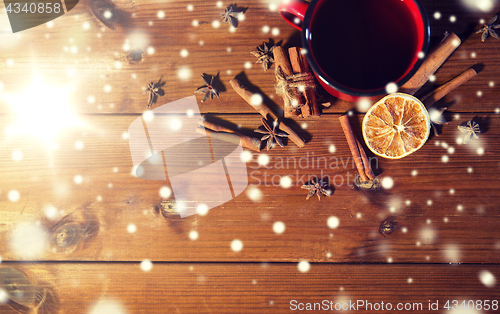 Image of tea cup with winter spices on wooden table