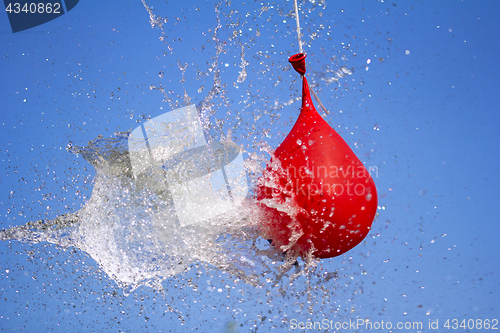 Image of Explosion of balloon full of water on sky background