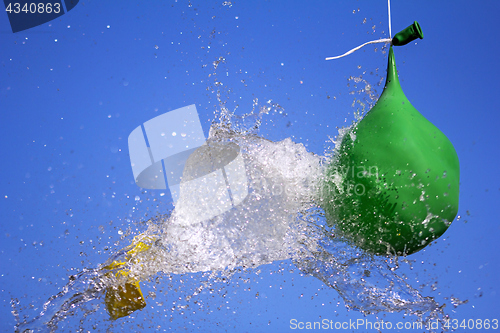 Image of Explosion of balloon full of water on sky background