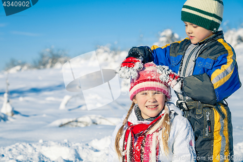 Image of Happy little children playing  in winter snow day.