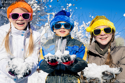 Image of Happy little children playing  in winter snow day.