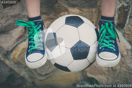 Image of Young little boy sitting  with soccer ball.