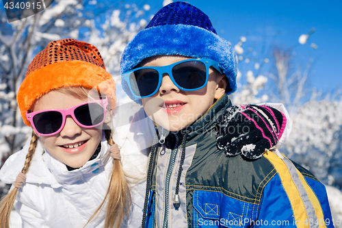 Image of Happy little children playing  in winter snow day.