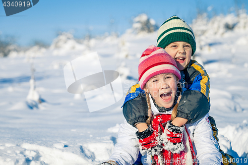 Image of Happy little children playing  in winter snow day.