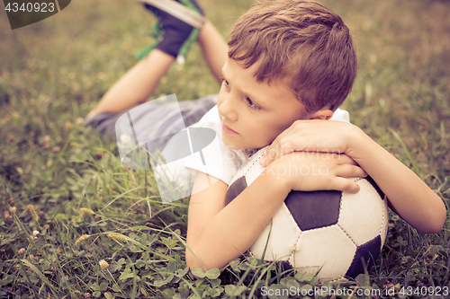 Image of Portrait of a young  boy with soccer ball.