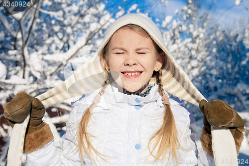 Image of Happy little girl playing  on winter snow day.