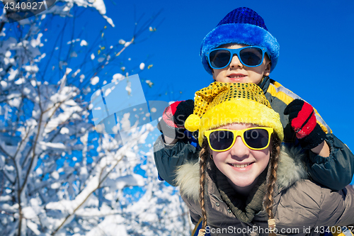 Image of Happy little children playing  in winter snow day.