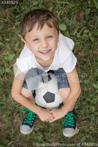 Image of Portrait of a young  boy with soccer ball.