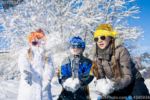 Image of Happy little children playing  in winter snow day.