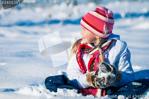 Image of Happy little girl playing  on winter snow day.